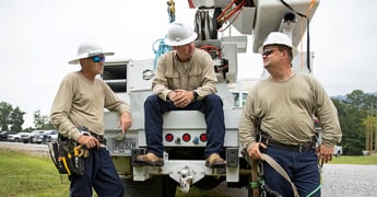 Three workers wearing protective clothing